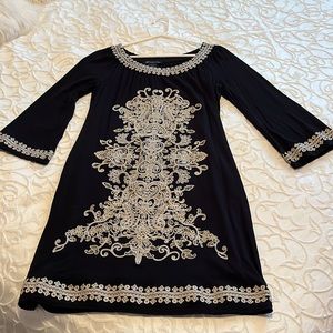 Little black dress with intricate white and gold embroidery pattern
